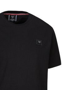 Schwarzes Baumwoll-T-Shirt mit Rundhalsausschnitt, kurzen Ärmeln und einem kleinen Markenpatch auf der oberen linken Seite.