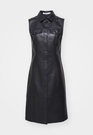 Svart skinnkjole uten ermer med krage, frontlukking med knapper, to brystlommer og vertikale sømdetaljer.