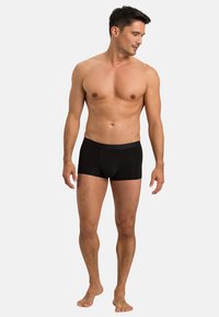 Svarta boxer-kalsonger med en åtsittande design, tillverkade av ett mjukt tyg. Har en mjuk midjeband och inga synliga mönster.