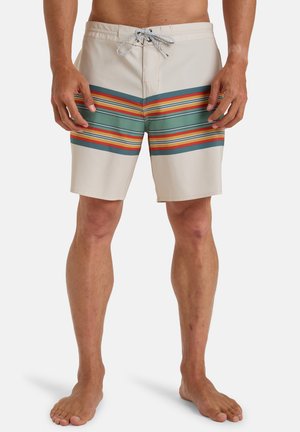 Un maillot de bain beige avec des rayures horizontales multicolores en vert, orange et rouge. Équipé d'une ceinture à cordon et de poches latérales.