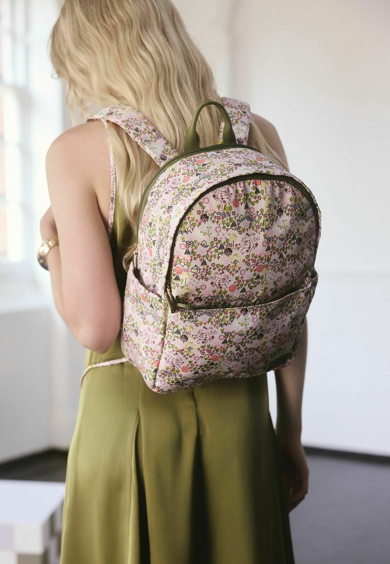 Virágmintás hátizsák pasztell rózsaszín és zöld színekben, lekerekített formával, textil cipzárral és párnázott pántokkal a kényelem érdekében.