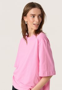 Rosa bomullströja med kort ärm och rundad halsringning, med en avslappnad passform och slät yta. Inga anmärkningsvärda designelement.