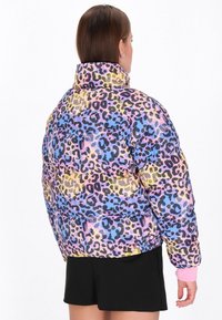 Pěnová bunda s barevným potiskem leopardího vzoru v růžové, modré a žluté barvě. Navržena s vysokým límcem a elastickými manžetami.