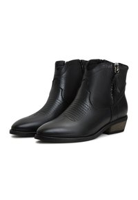 Botine din piele neagră, cu un finisaj texturat, vârf ascuțit, fermoare laterale și toc scăzut. Detaliu cu cusături decorative pe față.