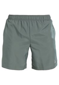 Zelené lehké sportovní šortky s elastickým pasem, bočními kapsami a malým reflexním logem na dolní levé straně.