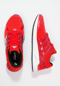 Zapatillas deportivas rojas con parte superior de malla, superposiciones sintéticas, amortiguación Cloudfoam y una media suela blanca. Presenta una suela negra y tres franjas.
