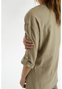 Beige linnen overhemd met opgerolde mouwen, knoopdetails, een relaxed fit en een zachte textuur, met een casual ontwerp en een lichte draping.