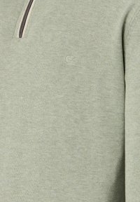 Lichtgroene gebreide trui met een kwart-rits en subtiele geborduurde logo op de borst.