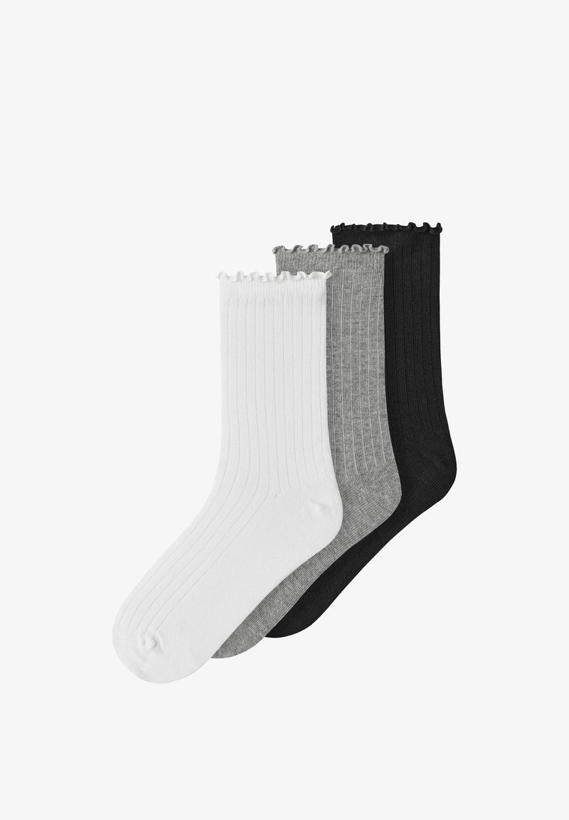 Trois paires de chaussettes courtes côtelées avec bords ondulés en blanc, gris et noir, empilées côte à côte sur un fond blanc.