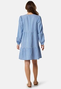 Blue and white striped dress with long puff sleeves, tiered skirt, and gathered waist detail. Soft fabric with a relaxed fit.