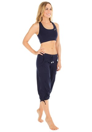 Navy sports bra and cropped pants made from breathable fabric; pants feature two side pockets and adjustable drawstring at the hem.