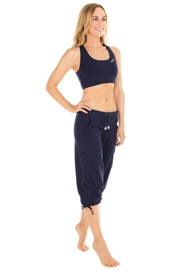 Merinen urheiluliivi ja lyhyet housut, jotka on valmistettu hengittävästä kankaasta; housuissa on kaksi sivutaskua ja säädettävä nyöri helmassa.