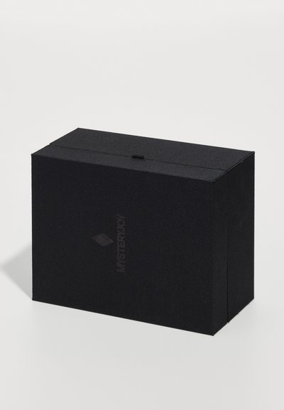 Melna taisnstūra kaste, izgatavota no teksturēta materiāla, ar izsmalcinātu logotipu un nelielu cilpiņu atvēršanai augšpusē.