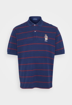 Mørkeblå polo skjorte med maroon horisontale striper, krage med to knapper, og brodert bjørnelogo på venstre bryst. Laget av bomull, med korte ermer.