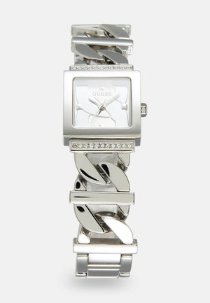 Montre en argent avec un cadran carré, mouvement à quartz, et un bracelet en chaîne décoratif accentué de strass transparents.