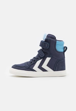 Marineblaue High-Top-Sneaker mit weißem Chevron-Design, samtartiger Textur, Klettverschluss und hellblauen Akzenten an der Ferse. Gummisohle.