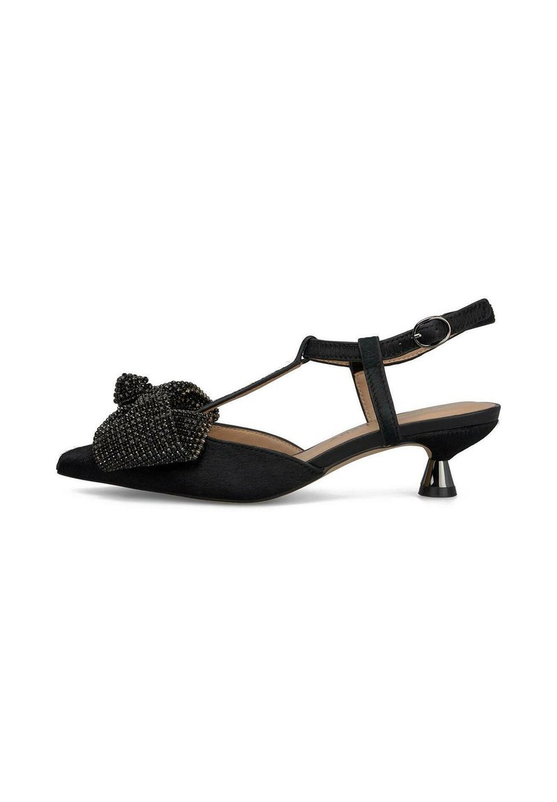 Scarpa slingback nera con punta appuntita, caratterizzata da un accento a fiocco di perline testurizzate e un piccolo tacco metallico. Realizzata in materiale morbido.