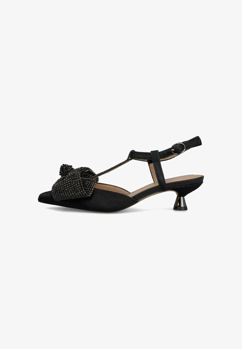 Zapato negro con tirantes traseros y punta afilada, adornado con un lazo de cuentas texturizadas y un pequeño tacón metálico. Confeccionado con material suave.