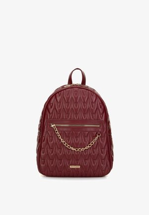 Burgundowa pikowana plecak z faux skóry o zaokrąglonym kształcie, z przodu kieszeń zdobiona złotym łańcuchem oraz uchwyt na górze.