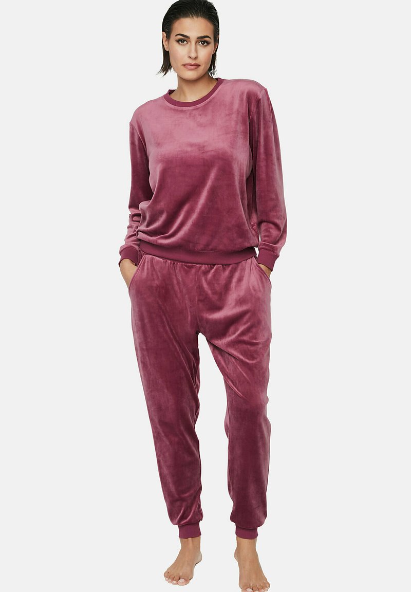 Ensemble de vêtements de détente en velours de couleur rose profond, avec des manches longues, des poignets et une taille élastiques, un ajustement décontracté et des poches latérales.