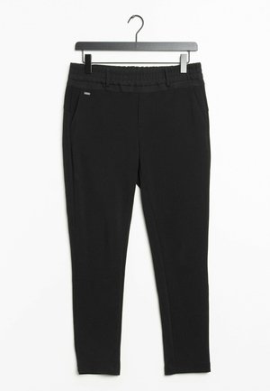 Pantalons noirs extensibles avec une taille élastique et des poches latérales. Le tissu semble lisse et doux, conçu pour le confort et la liberté de mouvement.