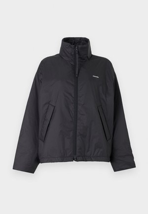 Black zip-up puffer jacket with high collar, side pockets, and small white logo on left chest against a plain light background.