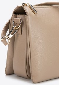 Borsa a tracolla beige in pelle con finitura texture, dotata di dettagli in oro, tracolla removibile e chiusura a zip nella parte superiore.