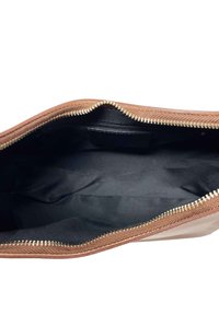 Borsa in pelle marrone testurizzata con zip dorata, dotata di un ampio interno nero e una piccola tasca interna. Nessun ulteriore decorazione.