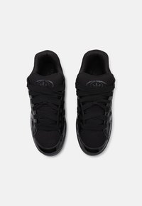 Svarta sneakers med en ovandel i mesh och blanka lackläderdetaljer. Har ett snörningsdesign och vadderad krage för komfort.