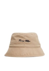 Beige bucket hat made of cotton with a wide brim. Features embroidered "Tommy Hilfiger" logo. Subtle textured fabric and two eyelets.