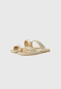 Gold glitter slide sandals with two wide straps, open toe design, and a flat sole. Features a smooth inner lining and minimalistic accents.