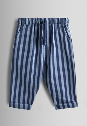 Prúžkované tepláky v modrej a námorníckej modrej farbe, s elastickým pásom so sťahovacou šnúrkou, bočnými vreckami a zrolovanými manžetami. Materiál z bavlnenej zmesi.