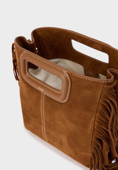 Καφέ τσάντα χειρός από σουέντ με δερμάτινη λαβή, διαθέτει υφή στην επιφάνεια και πλευρικά κρόσσια, παρουσιάζοντας έναν απλό, λειτουργικό σχεδιασμό.