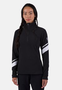 Svart fleecepullover med hög krage, prydd med silver- och vita ränder på armarna och dragkedja i halsen. Mjuk, strukturerad yta.