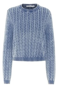 Suéter de punto azul claro con patrones de trenzas, cuello redondo y dobladillo acanalado. Detalle texturizado en las mangas y el cuerpo.