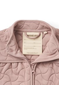 Lyserød quiltet zip-upp jakke med stående krave, der har en glat tekstur, synlige sømme og et plejelabel indeni.