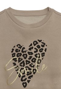 Bež dukserica s okruglim izrezom i rebrastim ovratnikom. Sadrži srce s crnim leopard uzorkom i riječ "Smile" u zlatnom metalik slovu.