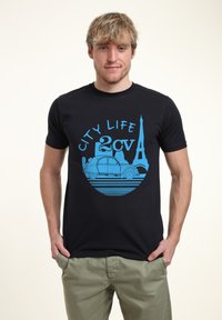 T-shirt in cotone nero con una grafica blu recante il testo "CITY LIFE" e un design di auto d'epoca accanto alla Torre Eiffel.