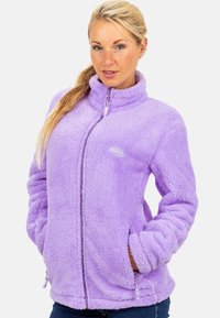 Veste en polaire violette avec un col haut, fermeture zippée et poches latérales. Tissu doux et texturé avec un logo sur la poitrine.