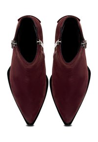 Un par de botas de tobillo de ante rojo oscuro con puntera afilada y cremalleras laterales, mostradas desde una vista superior sobre un fondo blanco.