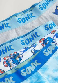 Drei Paar Jungenunterwäsche mit blauen und grauen Gummibündchen, die mit "SONIC" beschriftet sind, und bunten Cartoon-Motiven von Sonic the Hedgehog.