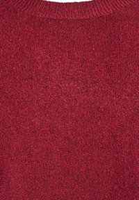 Adīts džemperis dziļi sarkanā krāsā ar mīkstu tekstūru; ar ribotu apkakli un vienkāršu rakstu visā virsmā.