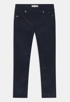 Pantalones de pana azul marino oscuro con pierna recta, con botones plateados y una etiqueta en la cintura. Textura suave y diseño clásico.