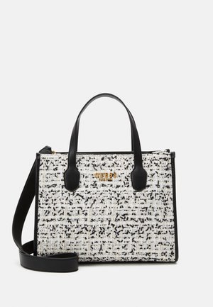 Rechteckige Schwarz-Weiß-Tweed-Tasche mit schwarzen Griffen, Schulterriemen und goldenem Guess-Logo vorne.