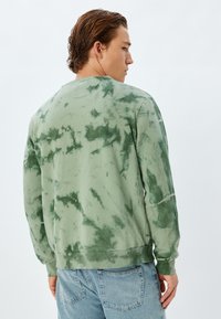 Grön tie-dye sweatshirt med rund halsringning och l�ånga ärmar, med en avslappnad passform och ribbade mudd- och nederkanter.