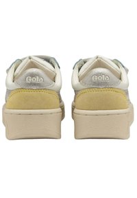 Zapatillas Gola con una parte superior de gamuza en gris, blanco y amarillo, que presentan una suela de goma texturizada y un logo grabado en el talón.