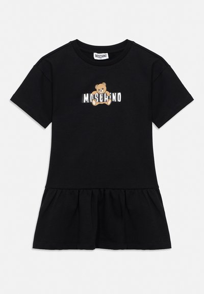 Μαύρο φόρεμα με κοντά μανίκια και βολάν στο τελείωμα, με κεντρικό σχέδιο αρκουδάκι και το κείμενο «MOSCHINO» στο στήθος.