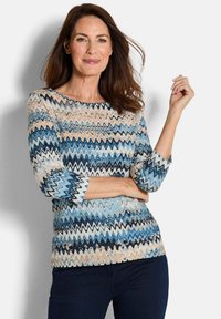 Langarmoberteil mit Wellenmuster in Blau, Creme und Rostfarben. Hergestellt aus strukturiertem Stoff, mit rundem Ausschnitt und enganliegenden Ärmeln.