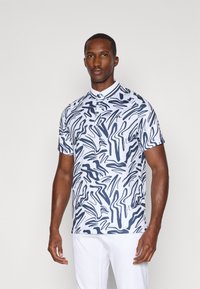 Polo de manga curta em branco com padrão abstrato em azul-marinho, apresentando um colarinho clássico e uma paleta de três botões. Textura suave.
