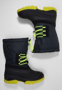 Bottes isolantes noires et grises avec une tige texturée, des lacets vert vif et une semelle épaisse jaune. Dotées d'un col rembourré pour la chaleur.
